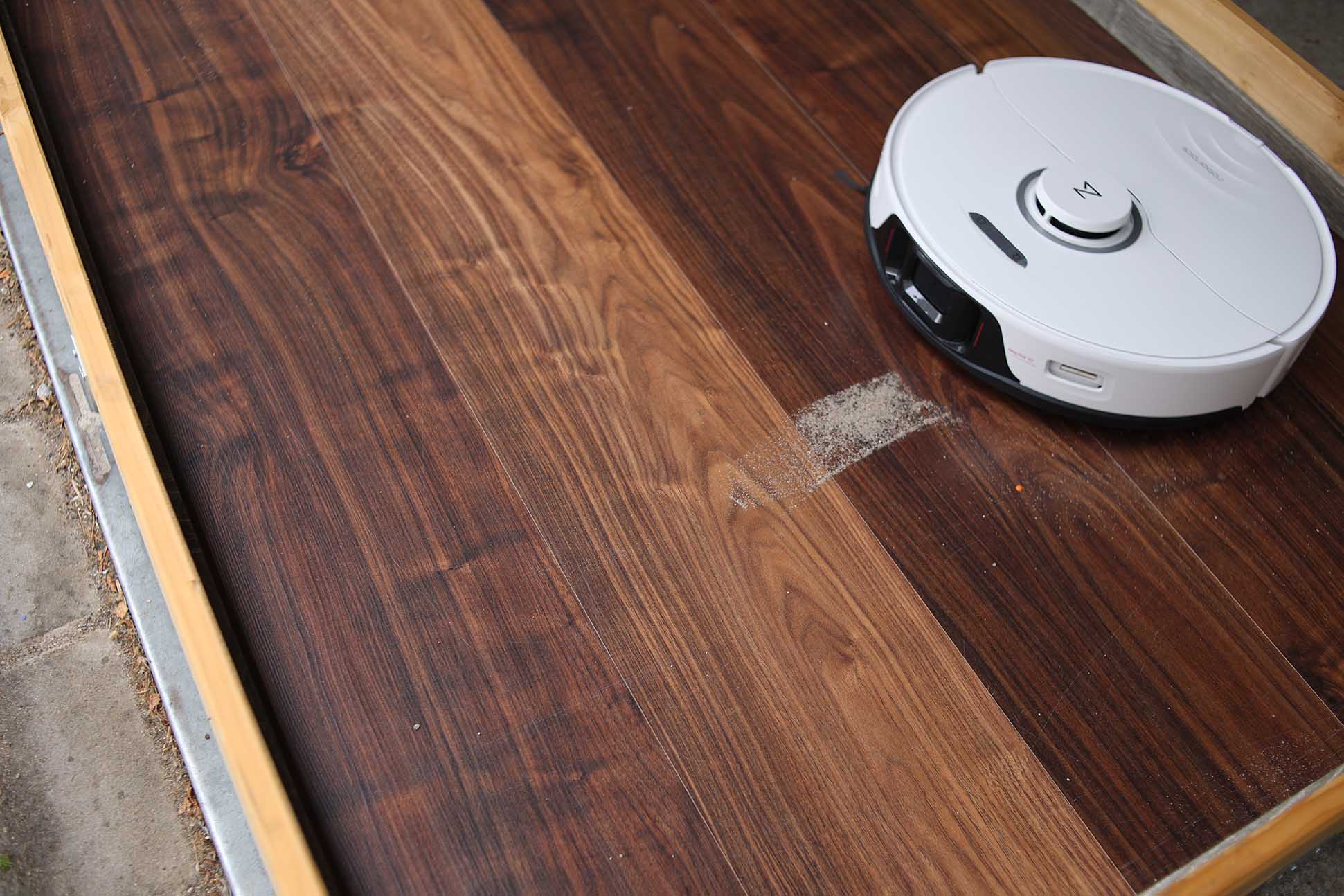 Roborock S8 Pro Ultra убирает песок в тесте на мощность всасывания на ламинате.